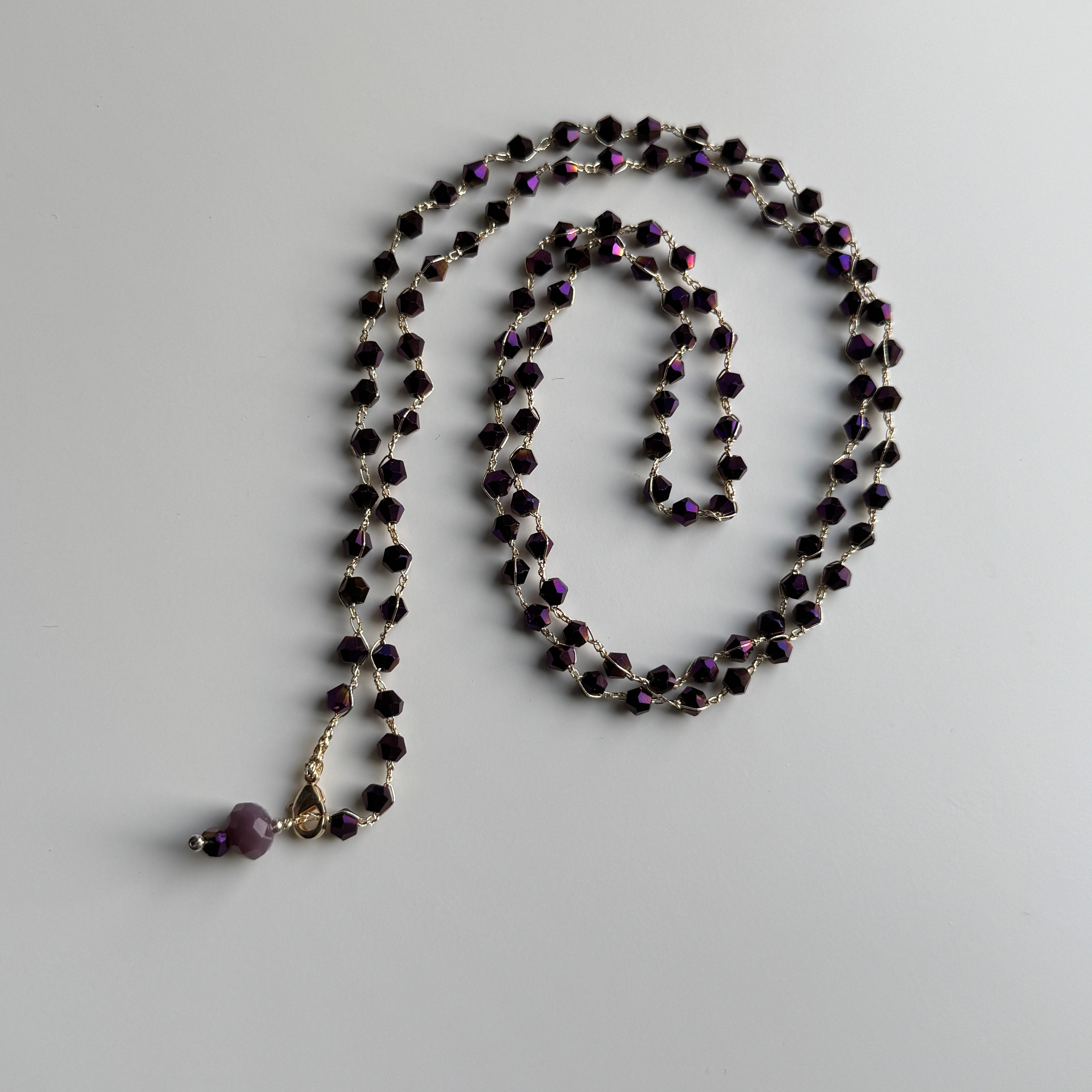 tamsiai violetinių bicone formos karoliukų vėrinys