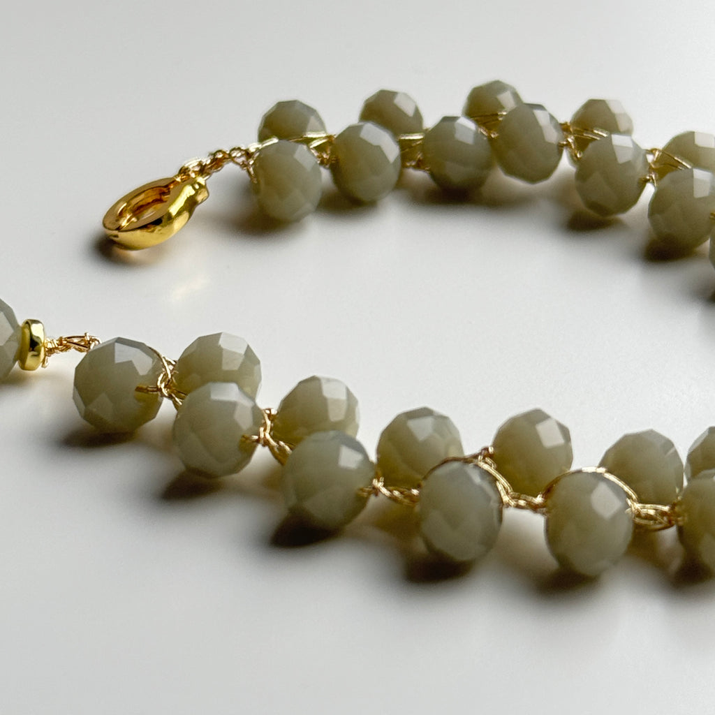 vąšeliu nerta pilkos spalvos stiklo kristalų apyranė su aukso spalvos užsegimu