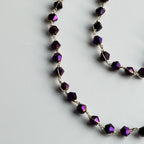 Necklace with purple beads on a light gray background
