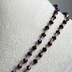 Necklace with purple beads on a light gray background