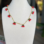 auksinių siūlų ir vyšnių kaklo papuošalas