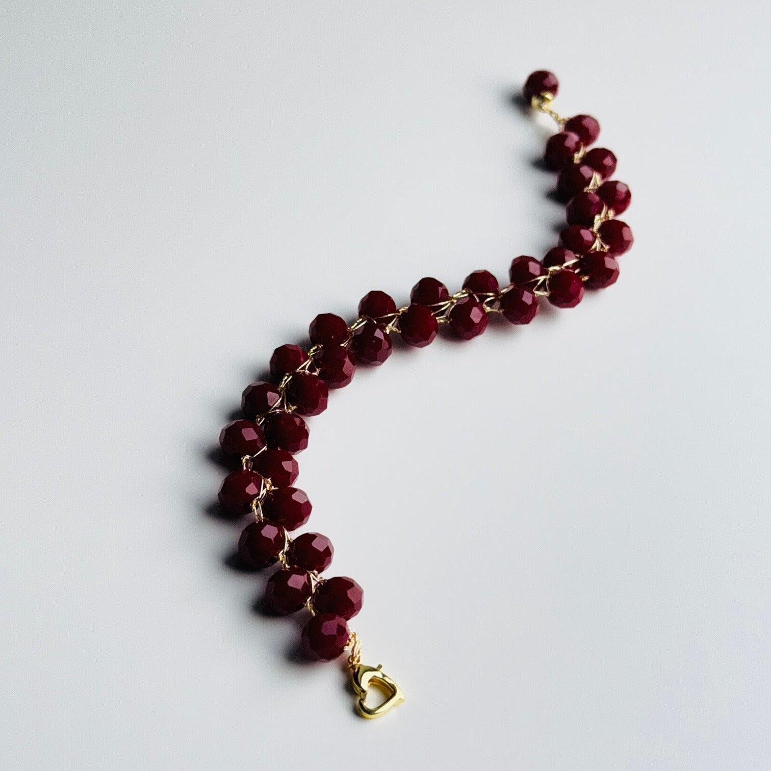 bordo karoliuku apyranke su paauksuotu širdies formos užsegimu