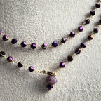 Two beaded necklaces with purple beads on a light gray background