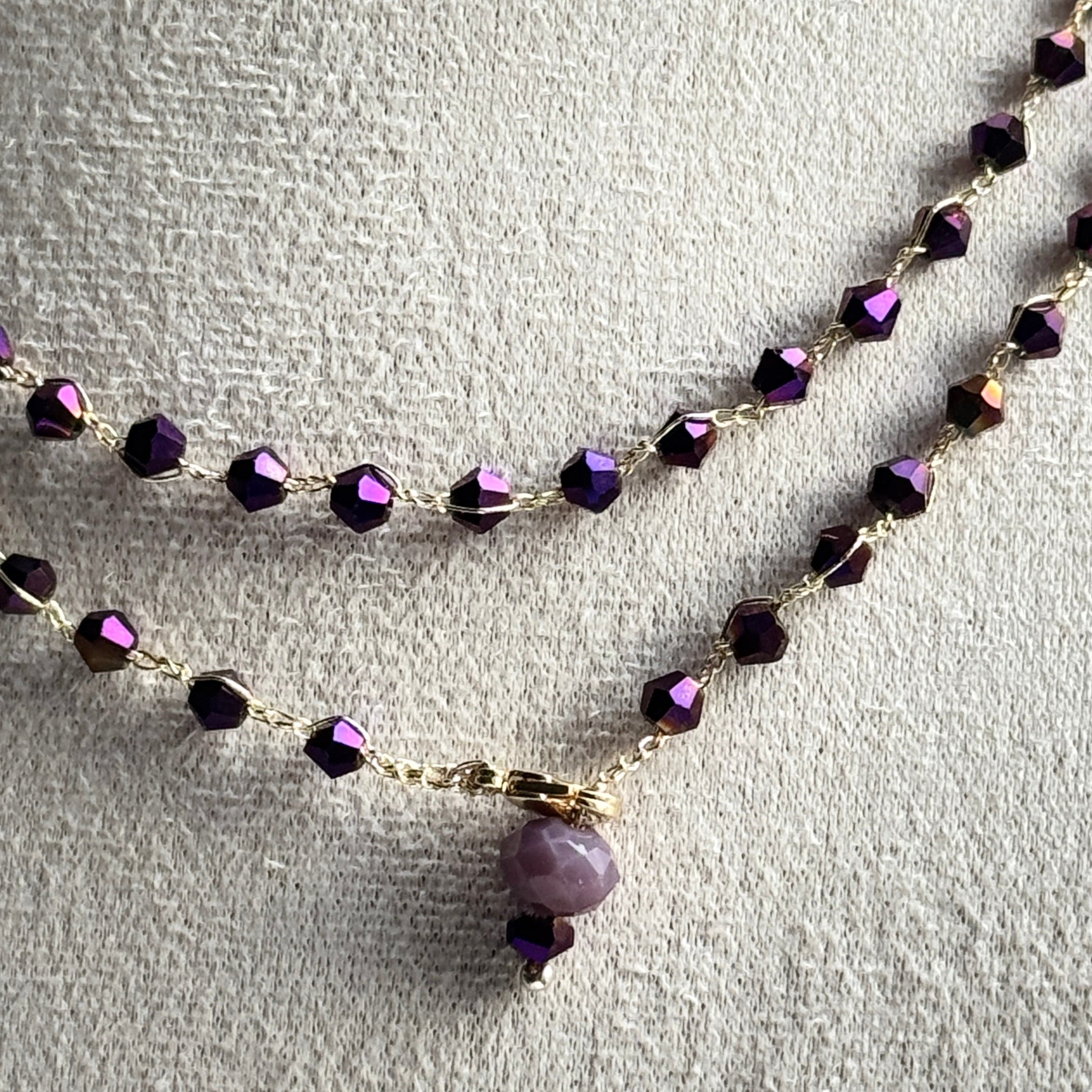 Two beaded necklaces with purple beads on a light gray background