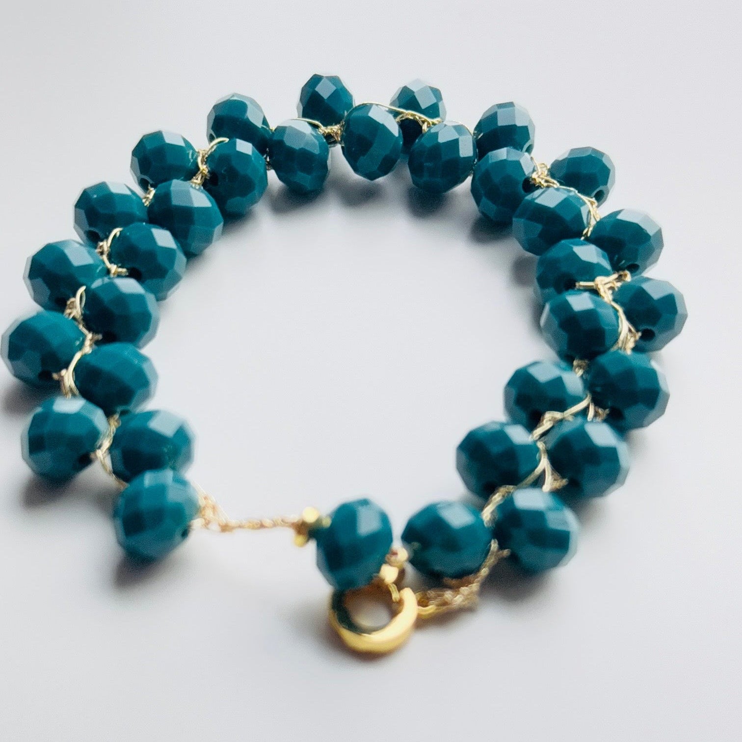 melsvai žalsvų karoliukų apyranke su auksiniu užsegimu