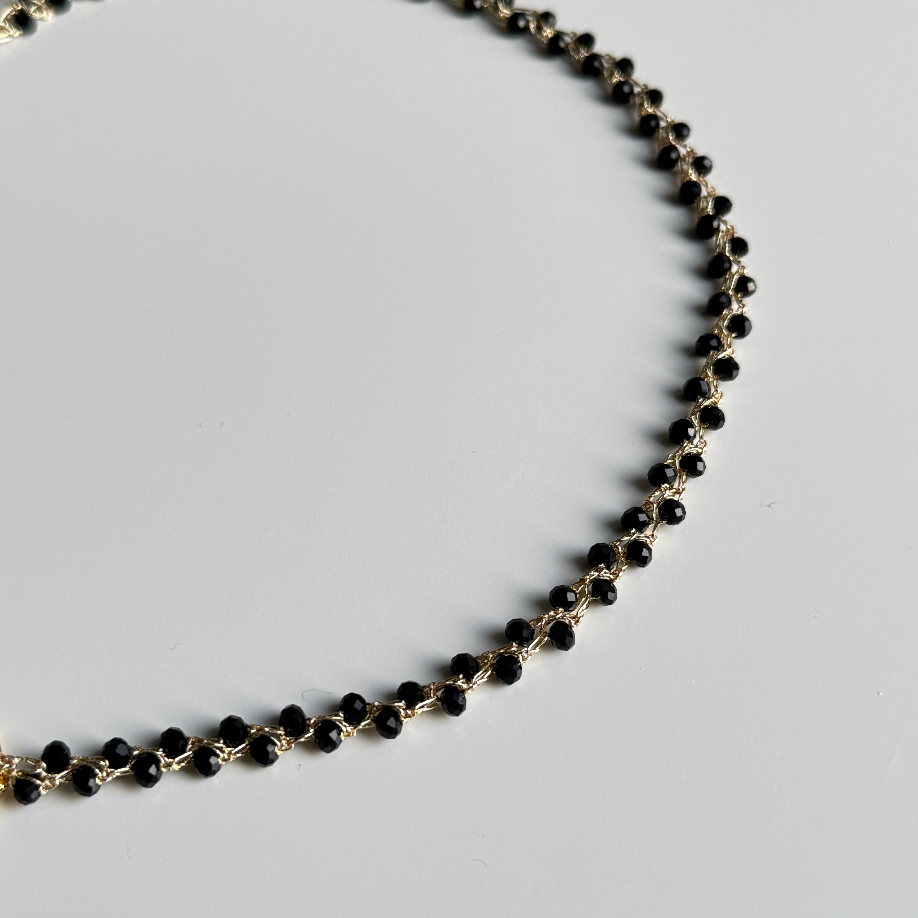 kaklo papuosalas ant auksinio atspalvio sidabrinio siulo su juodais stiklo kristalu karoliukais