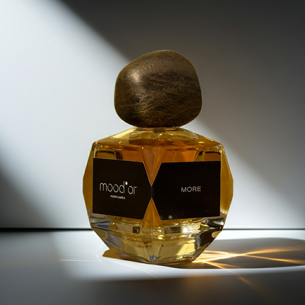 kvepalų buteliukas apšviestas šviesos spinduliu