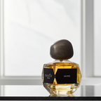 kvepalų buteliukas su užrašu more, stovi ant palangės