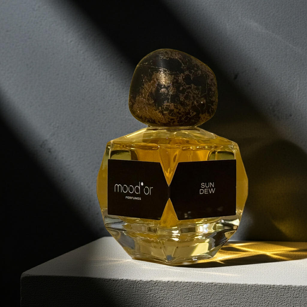 Perfume bottle labeled 'mood'or Sun Dew on a dark background